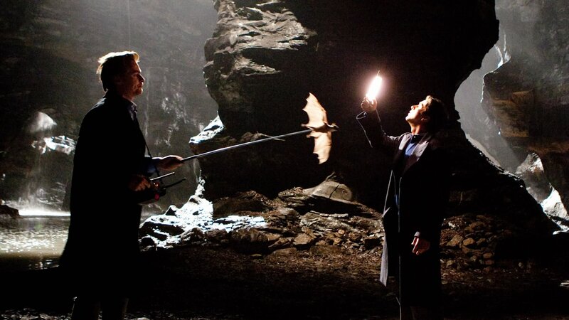 Men in a dark cave with bat