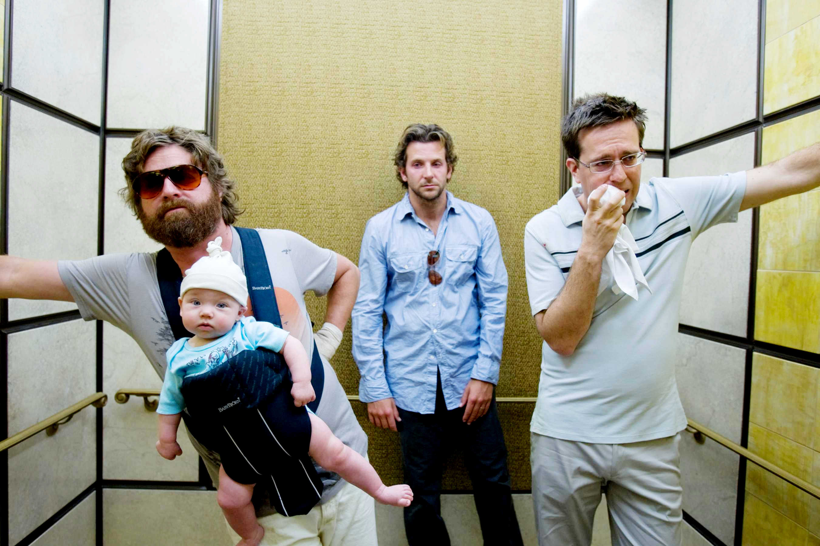 Men in an elevator with a baby