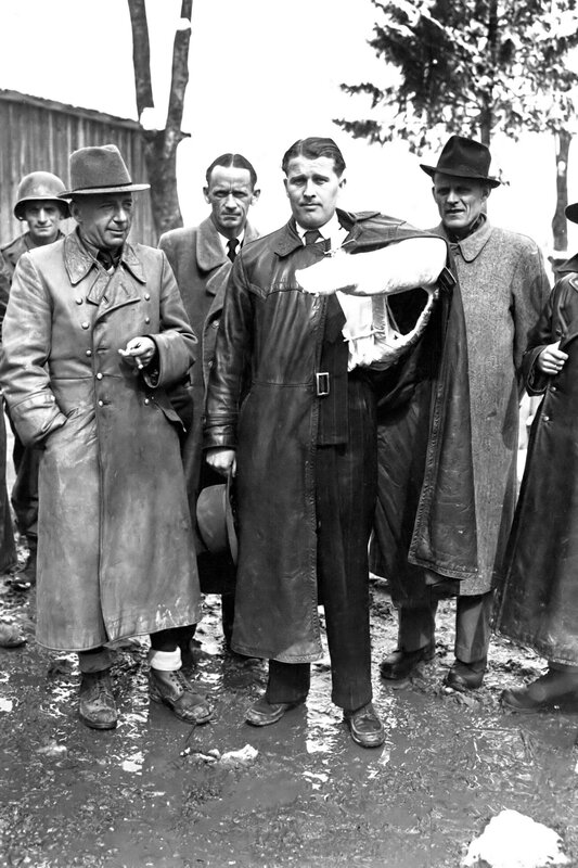 Men in coats at a muddy site