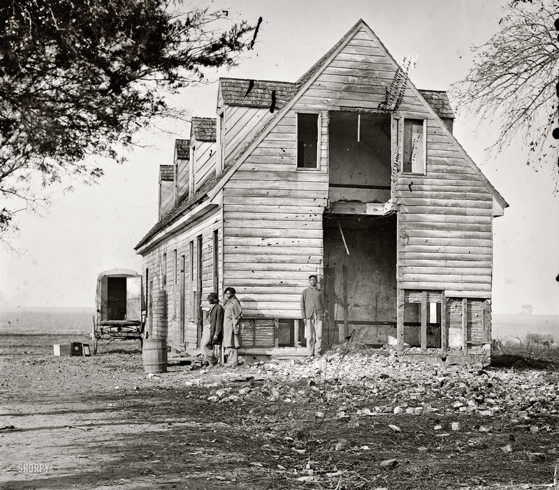 Men in front of damaged house