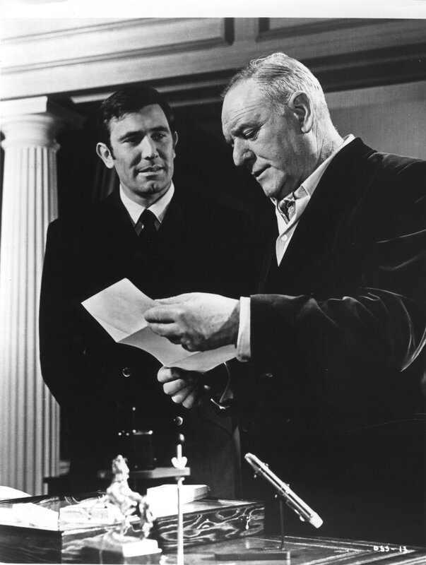 Men in suits examining a document