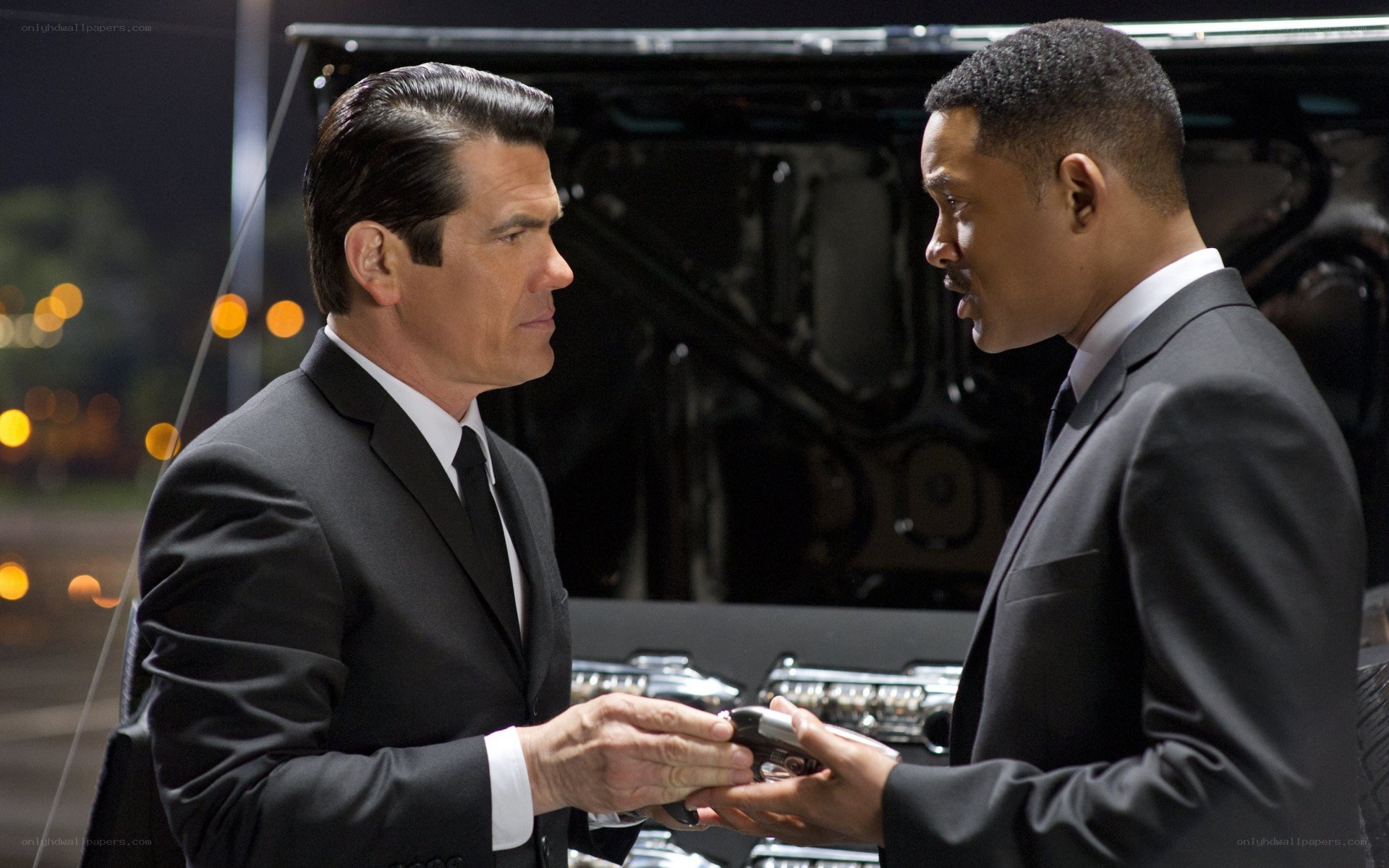 Men in suits exchanging device