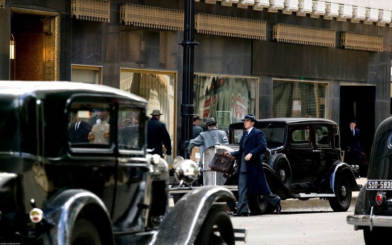 Men in suits with vintage cars