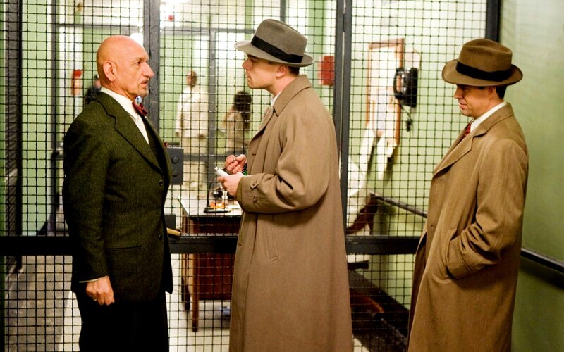 Men in trench coats in a prison