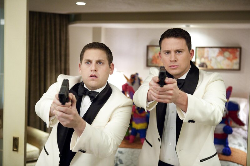 Men in tuxedos holding guns