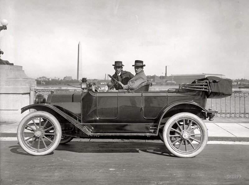 Men in vintage car with Washington Monument
