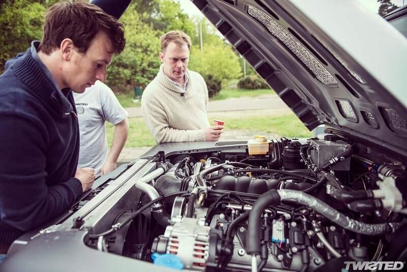 men inspecting car engine