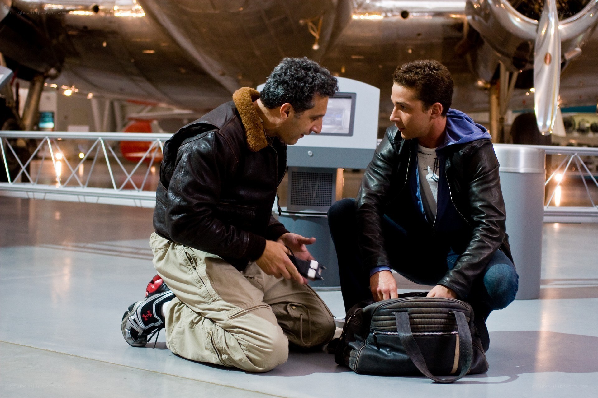 Men kneeling in aircraft hangar