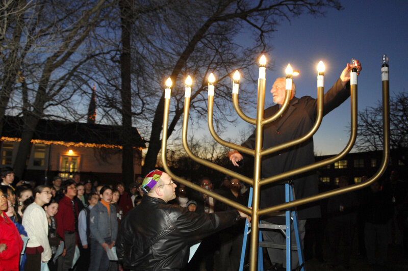 Men lighting a large menorah