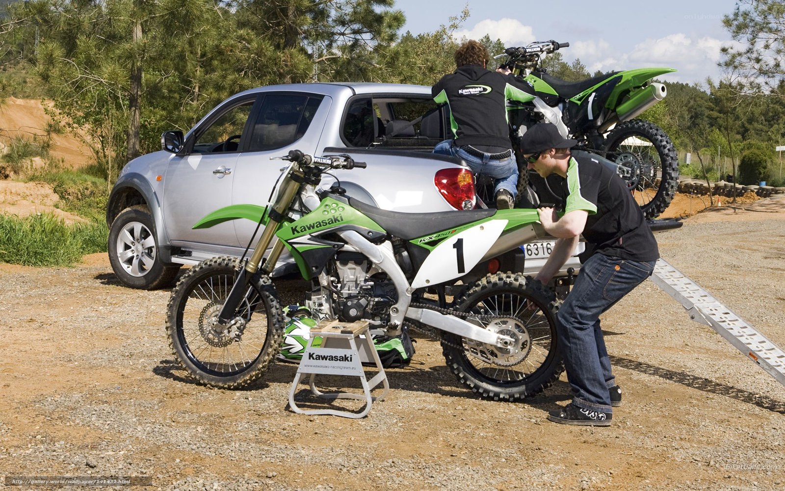Men loading dirt bikes into truck