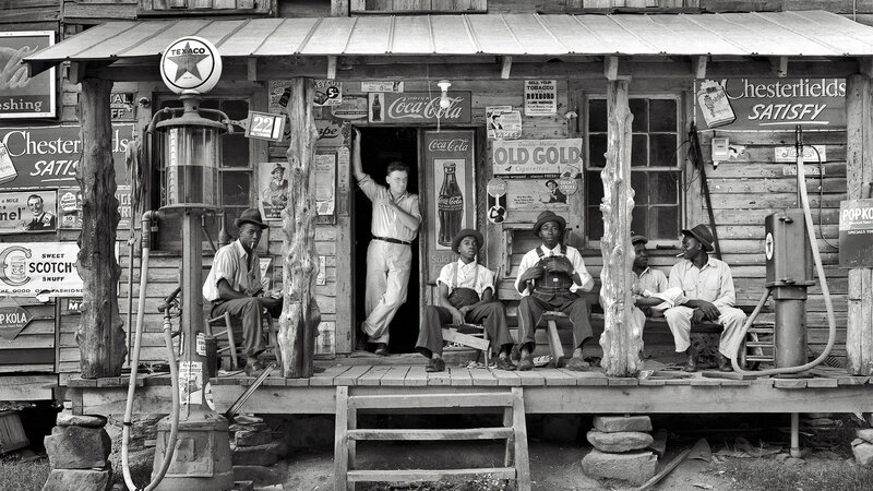 Men on a porch at a general store