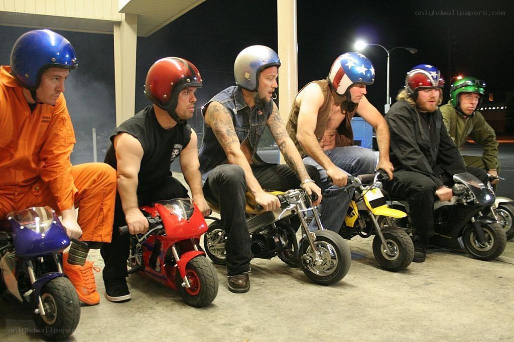 men on mini motorcycles at night