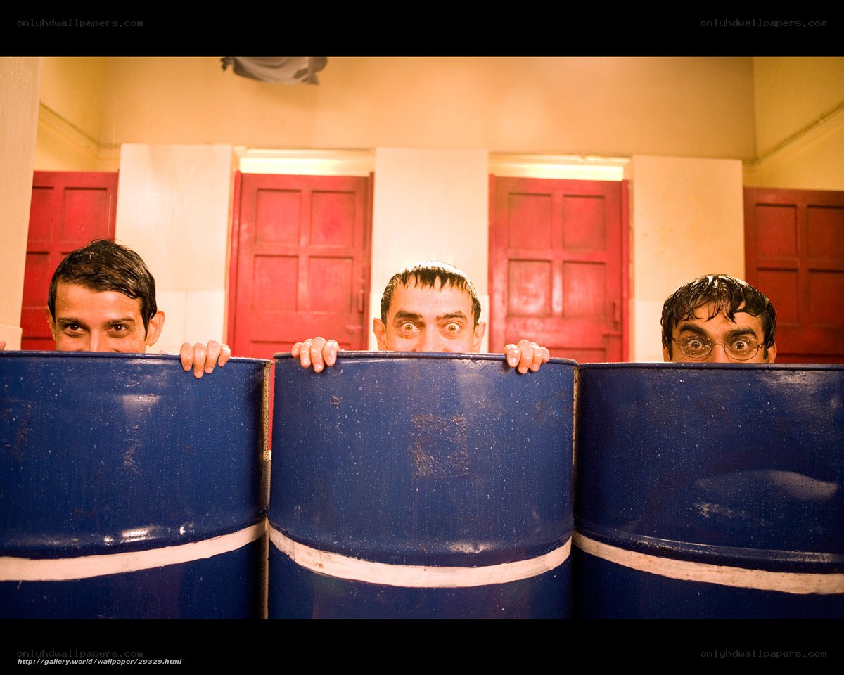 men peeking from behind barrels