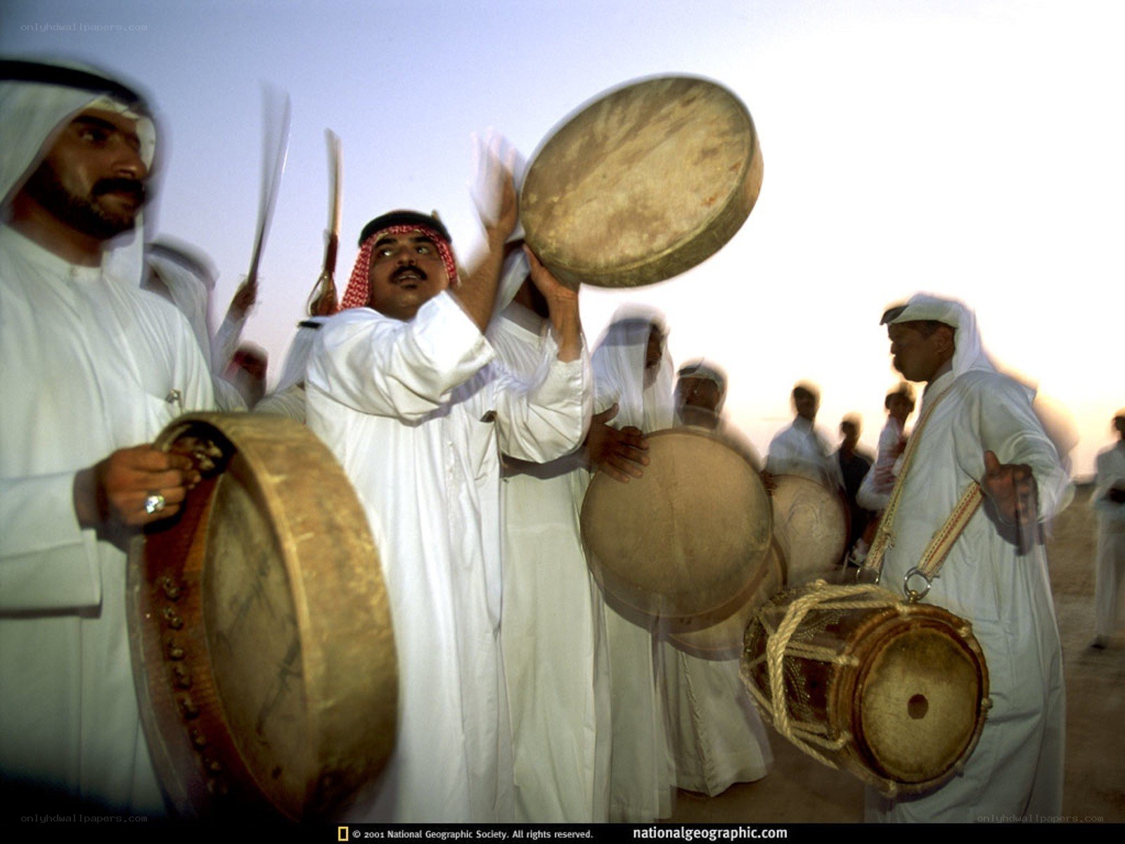 Men playing drums in desert