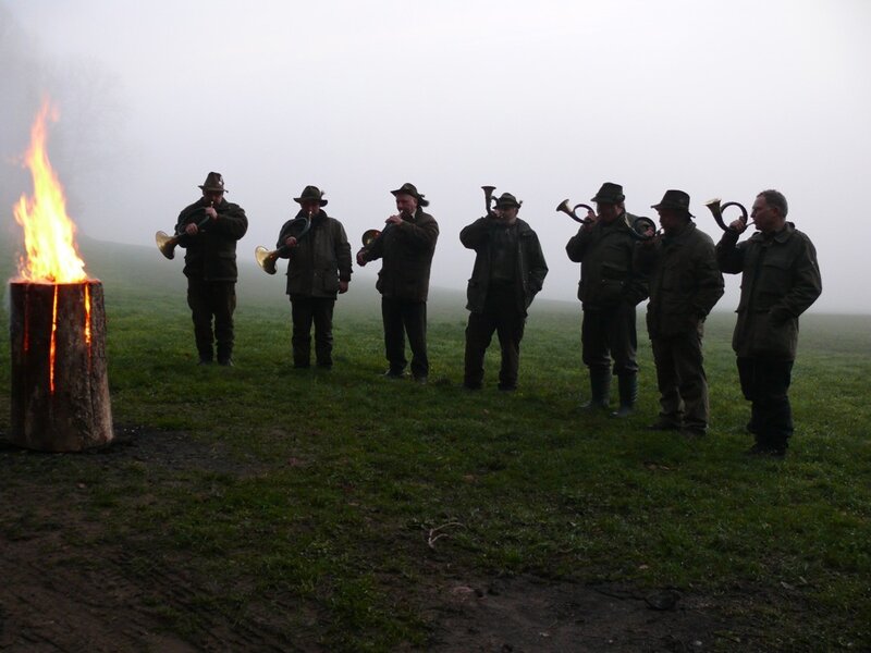 Men playing horns by a fire