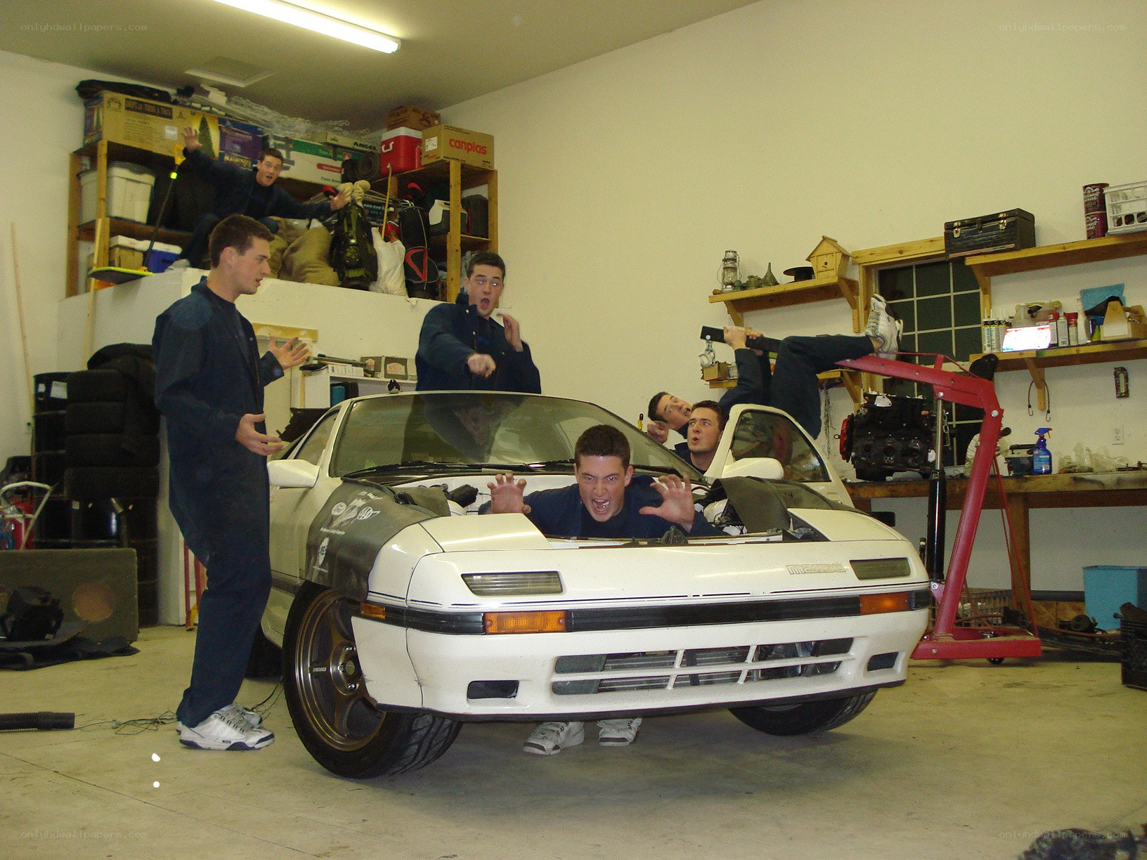Men posing with car in garage