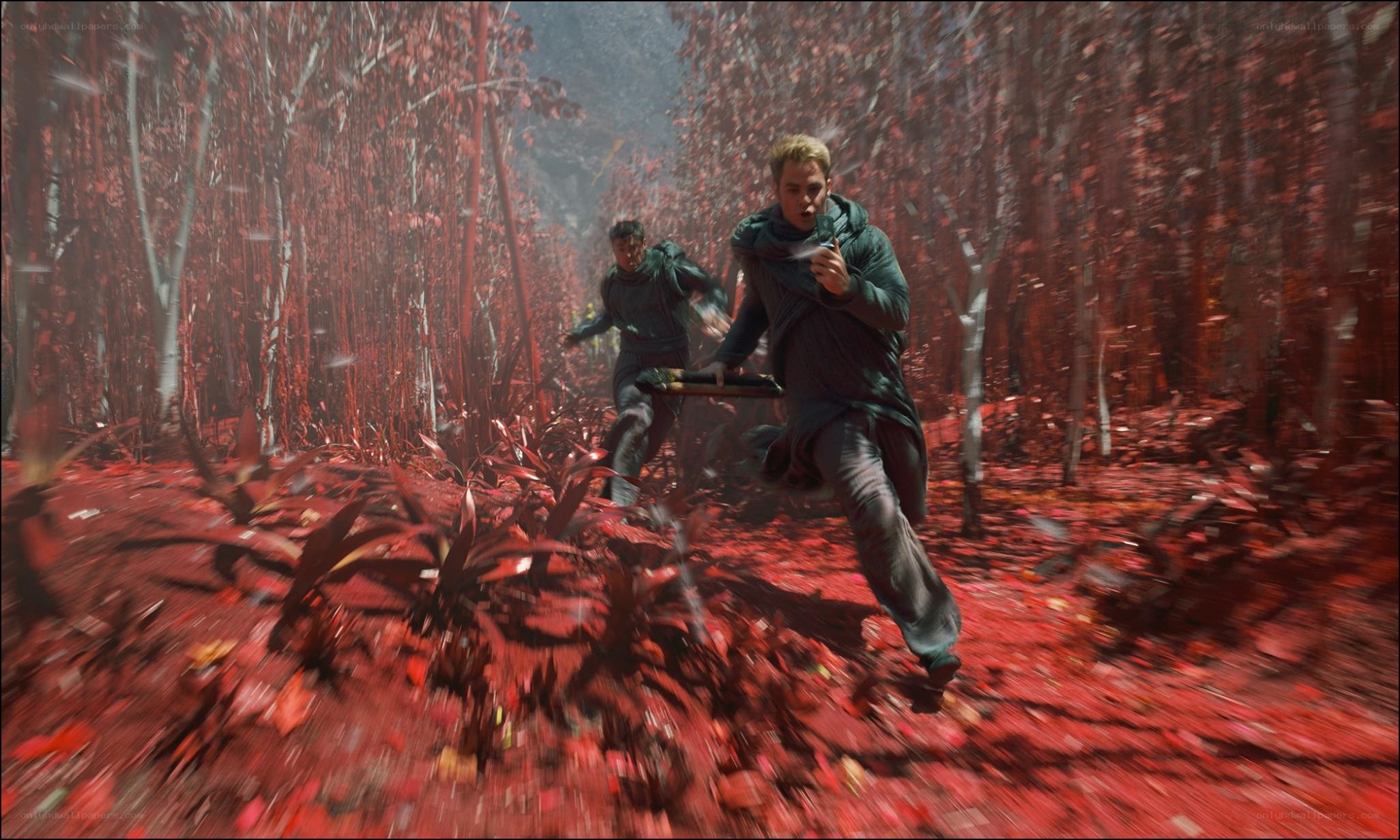 Men running through red forest