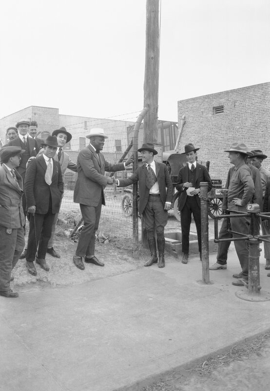 Men shaking hands at a gate