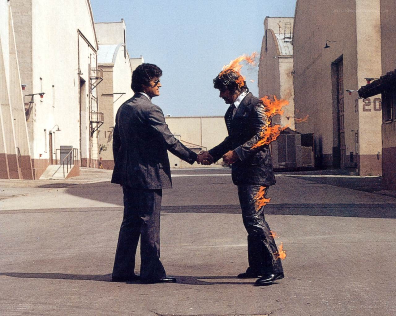 Men shaking hands with one on fire