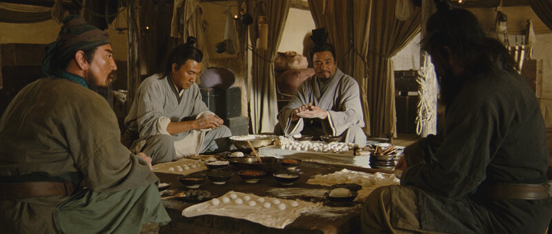 men sharing a meal in ancient setting
