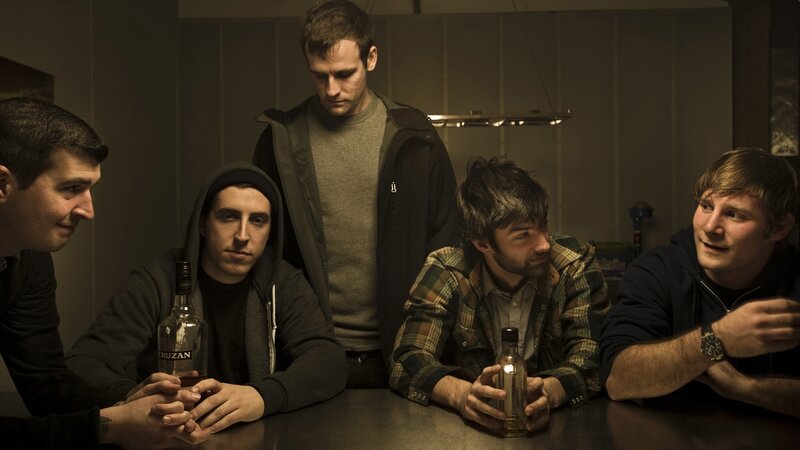 men sitting at a table with bottles