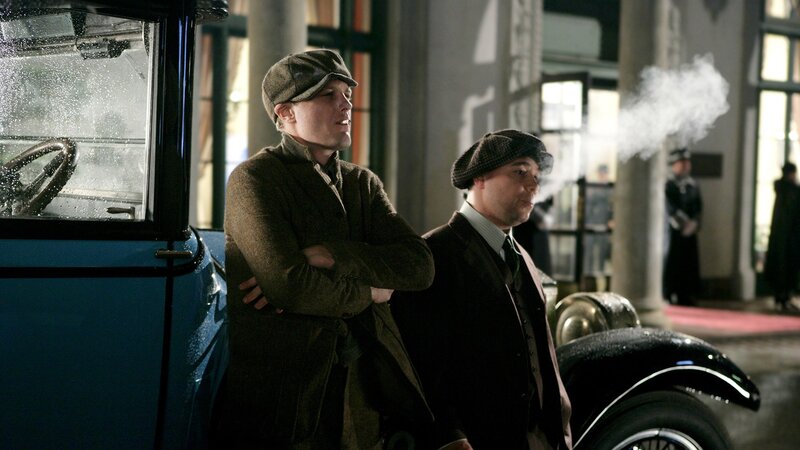 Men standing by vintage cars