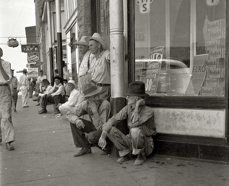 Men waiting on a city sidewalk