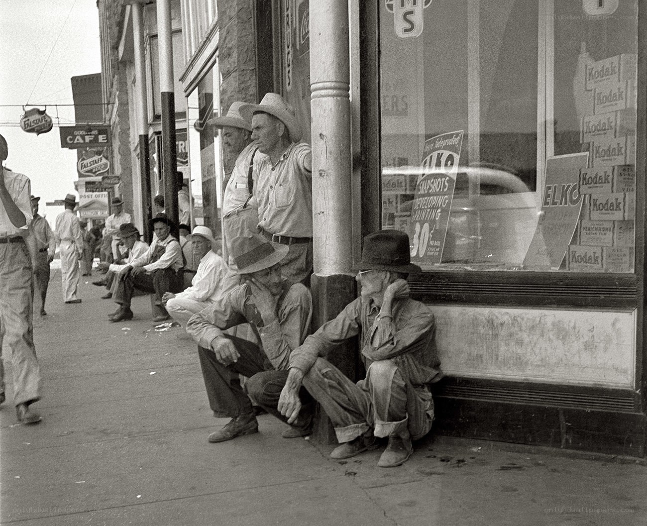 Men waiting on a city sidewalk