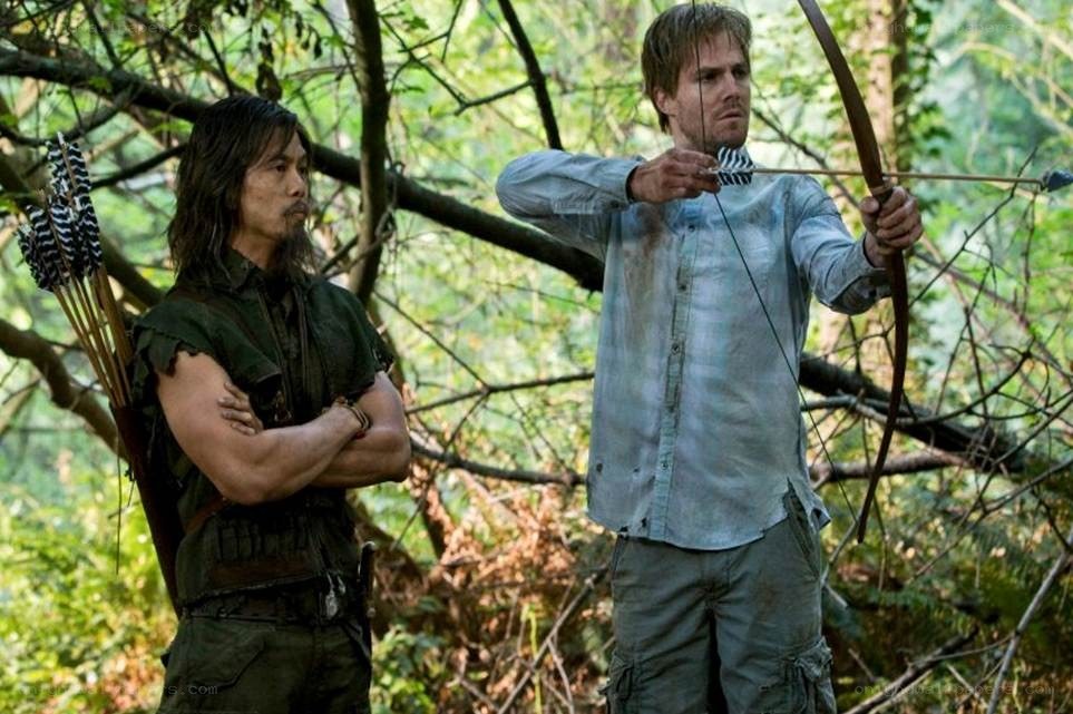 Men with bow and arrow in forest