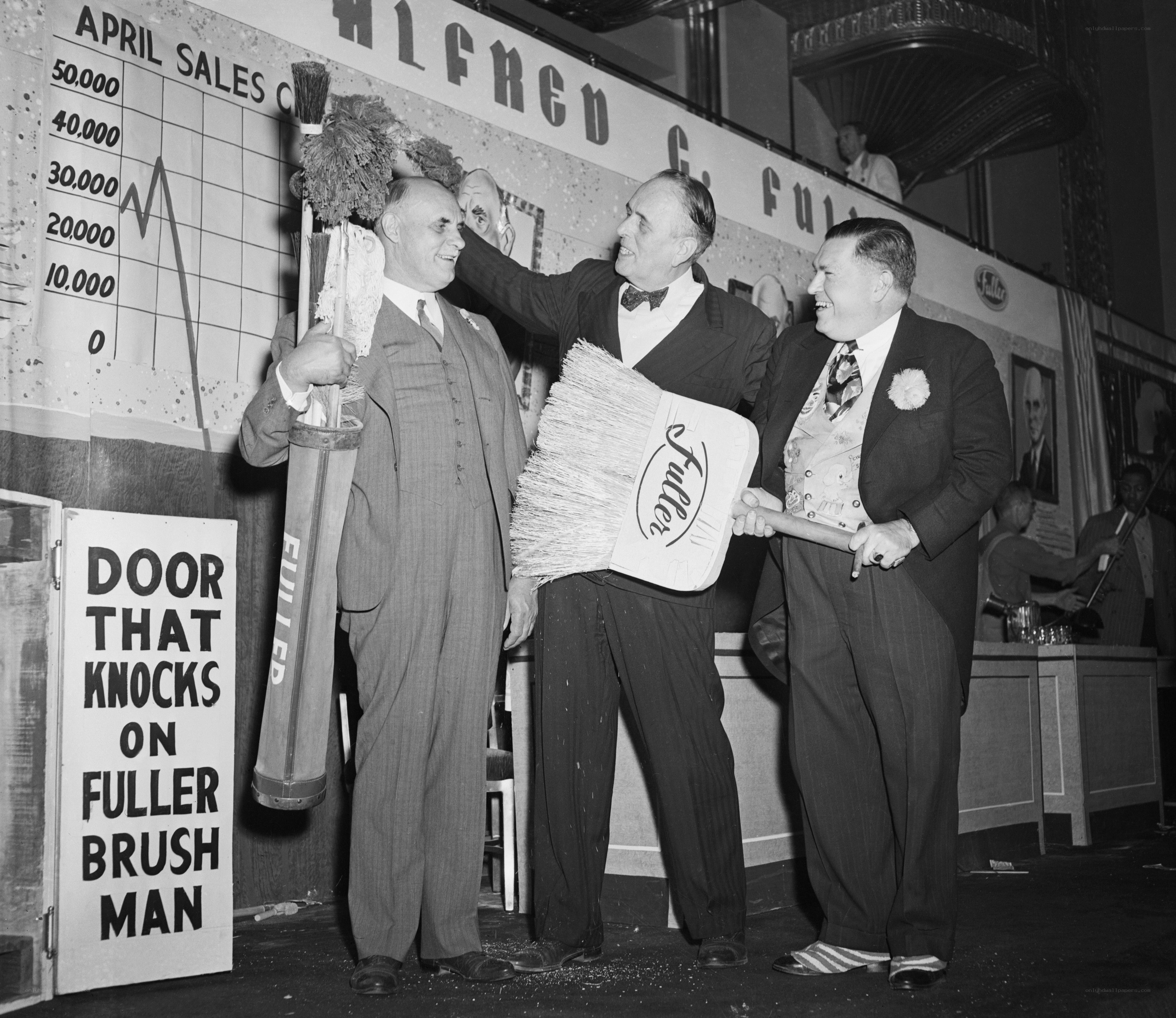 Men with brooms on stage