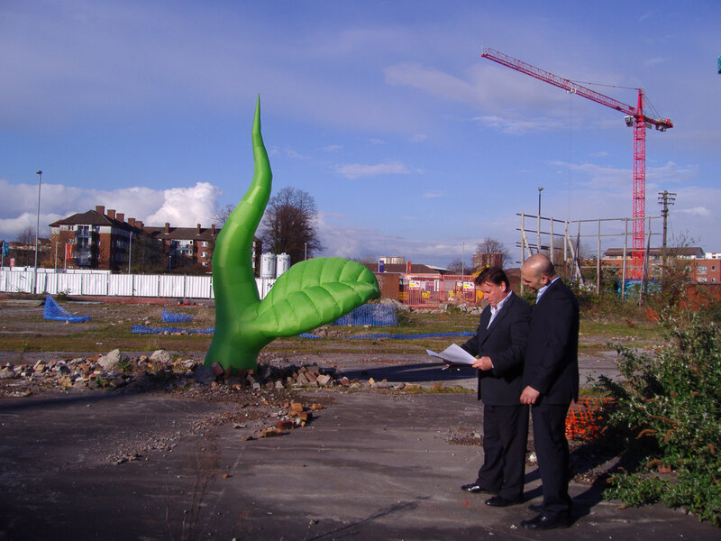 Men with paper near green sculpture