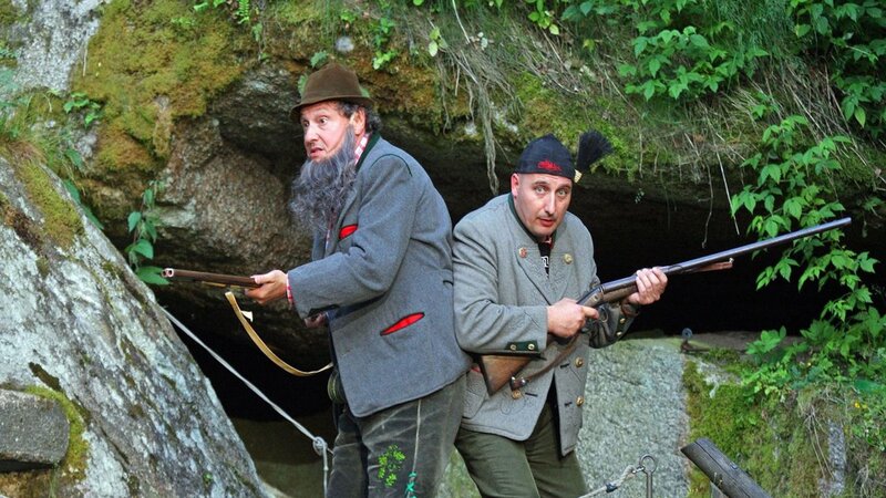 Men with rifles in cave entrance