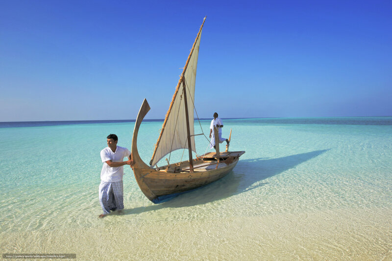 Men with sailboat on beach