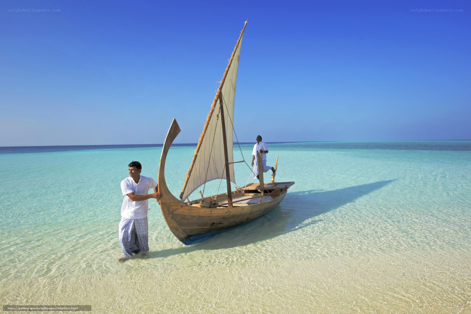 Men with sailboat on beach