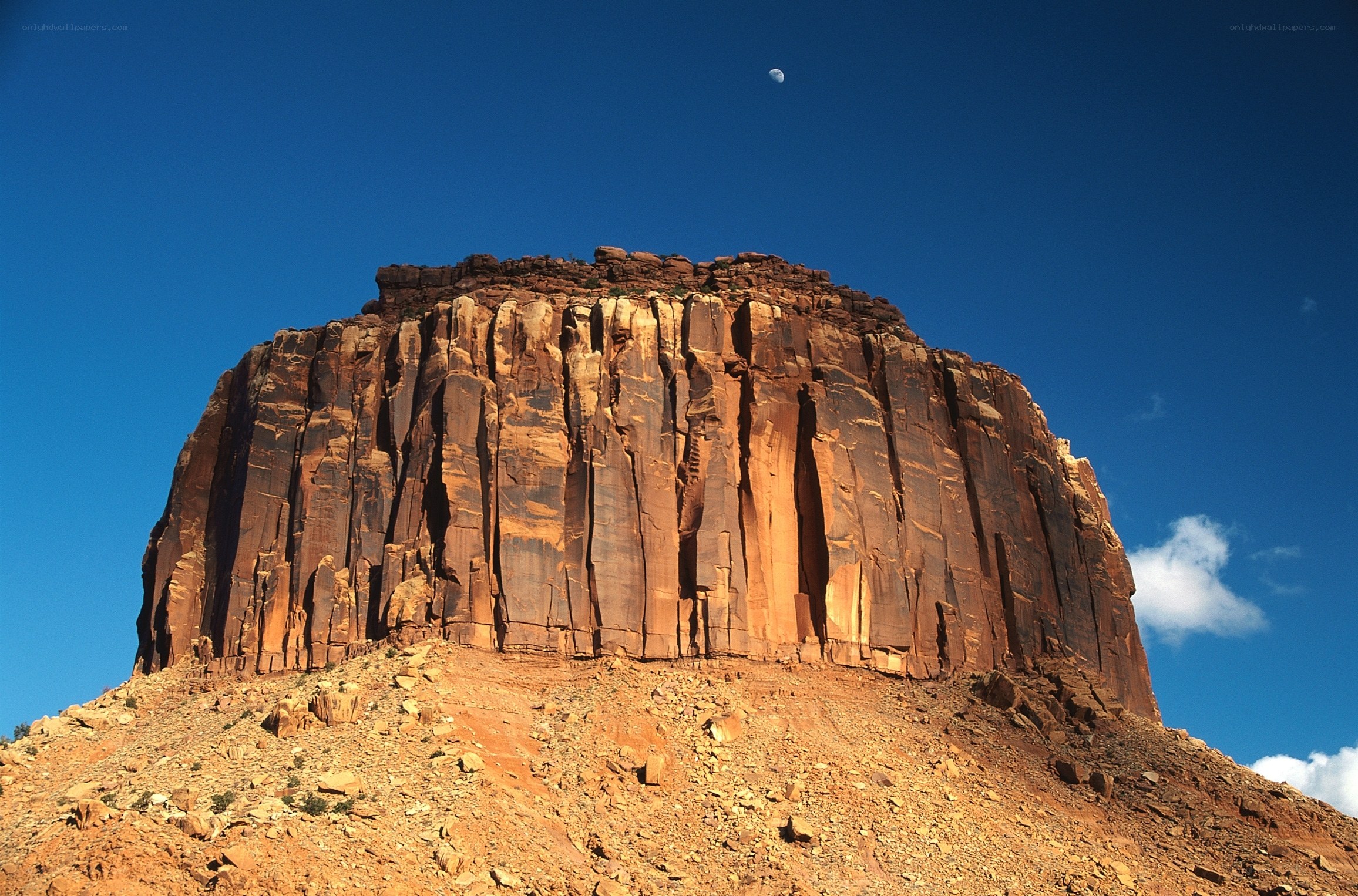 Mesa with moon in blue sky