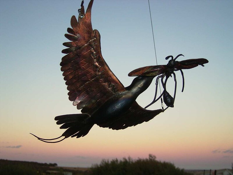 Metal bird sculpture with insect