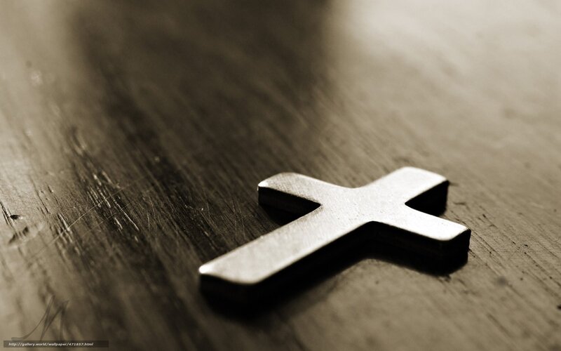 Metal cross on wooden surface