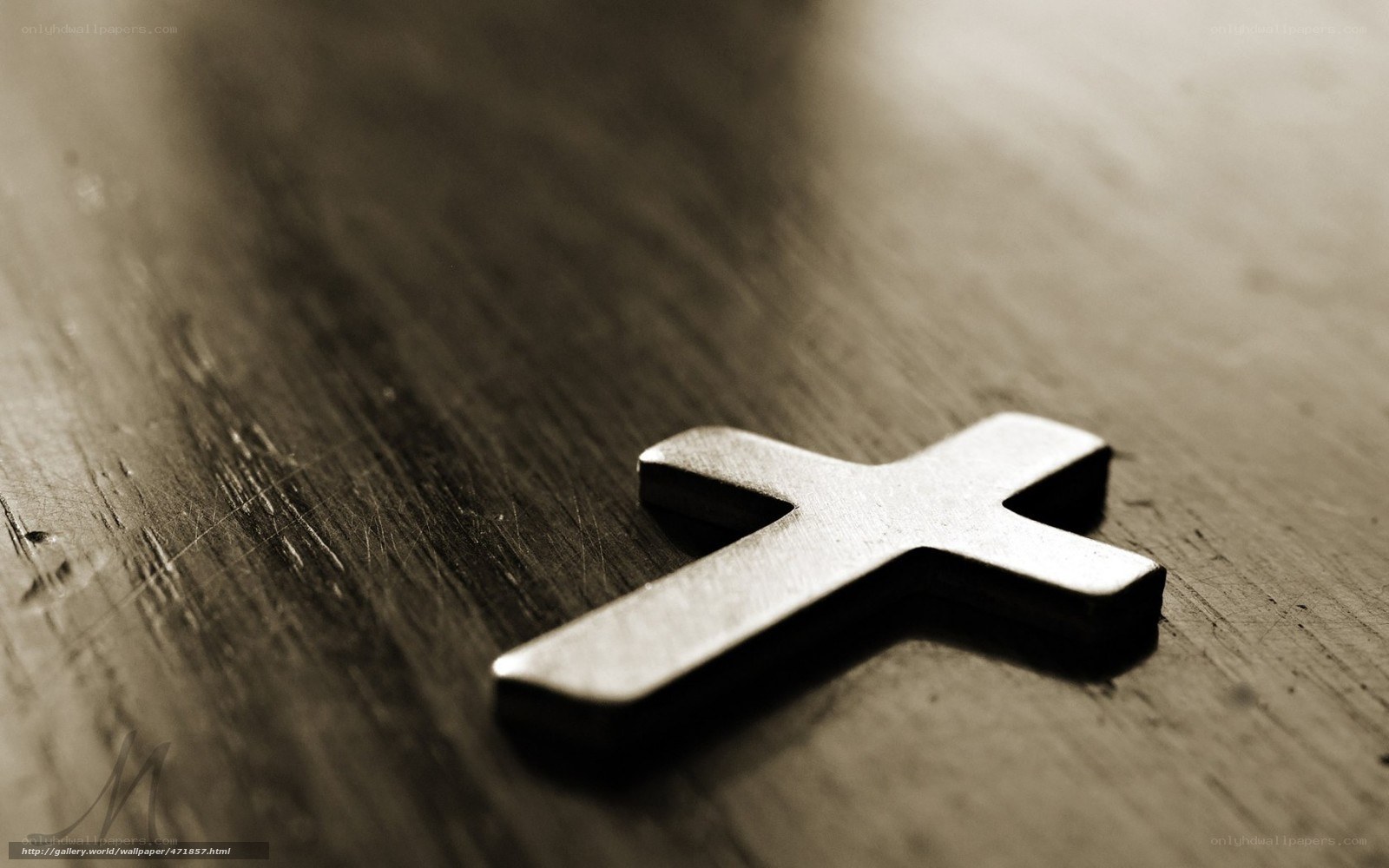 Metal cross on wooden surface