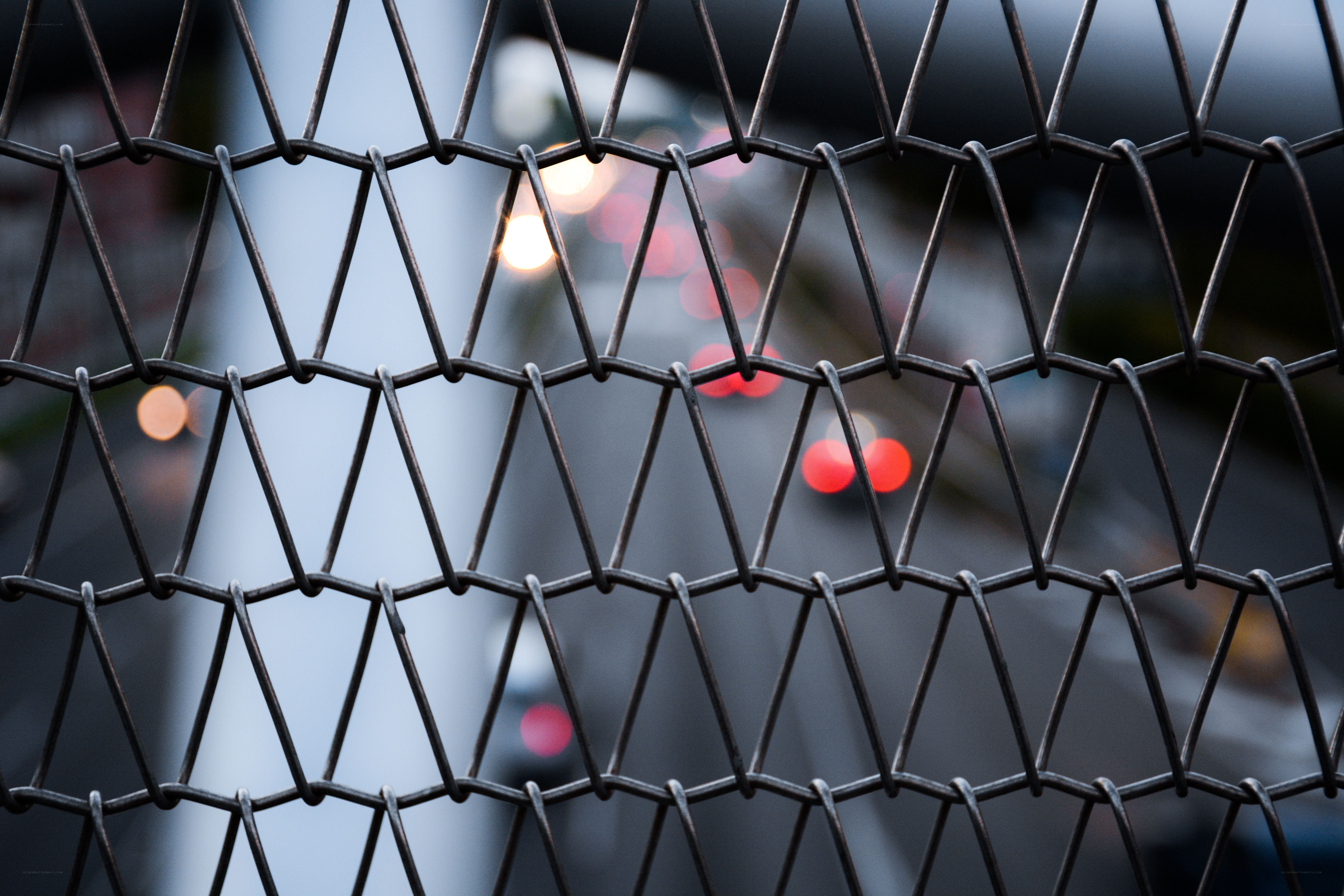 Metal fence with city lights