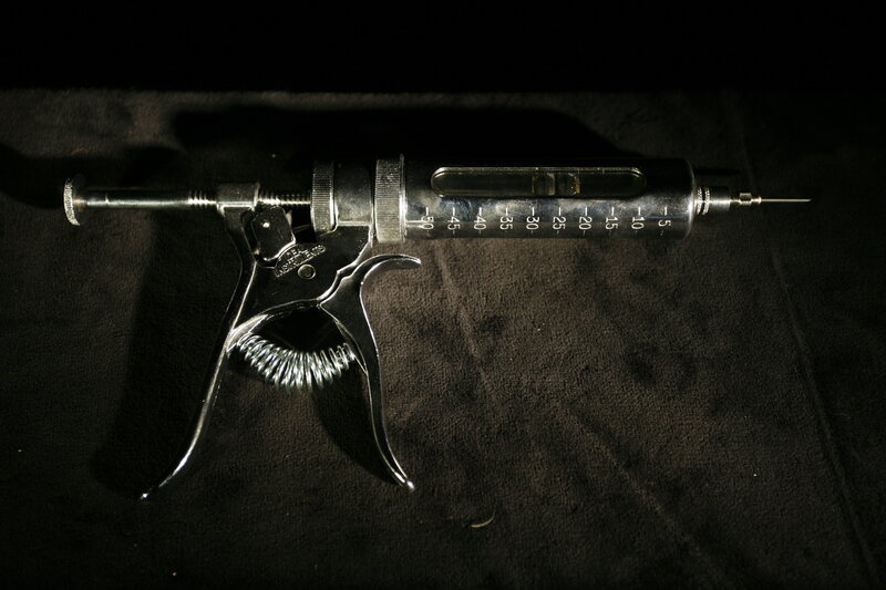 metal syringe on black cloth