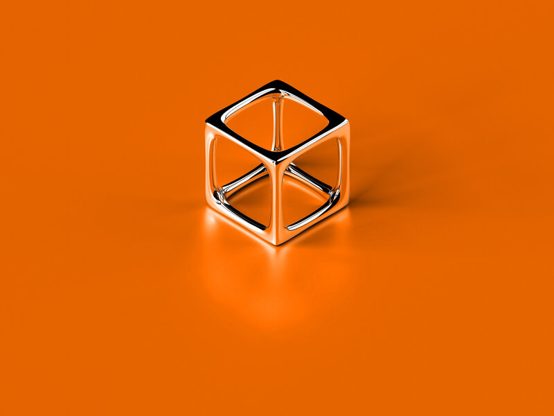 Metallic cube on orange surface