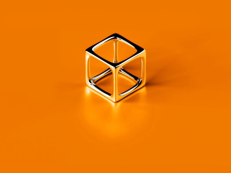 Metallic cube on orange surface