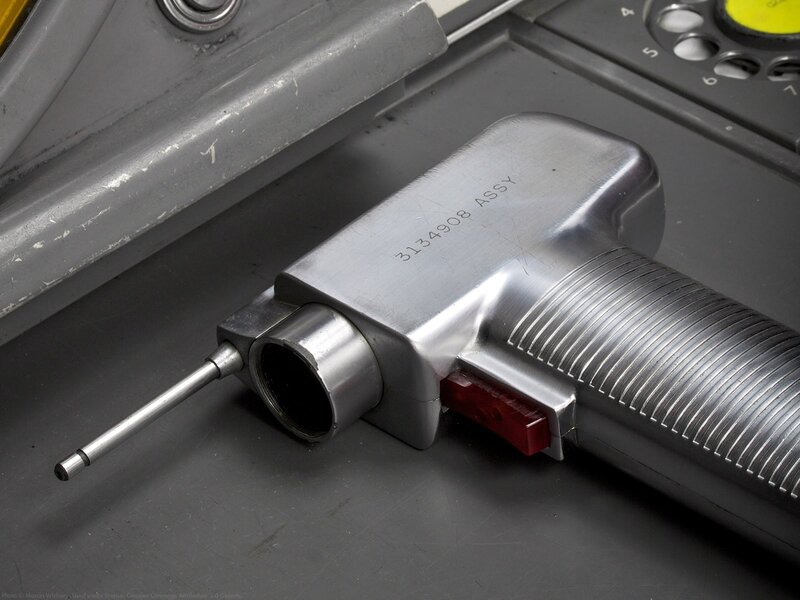 metallic tool with red switch