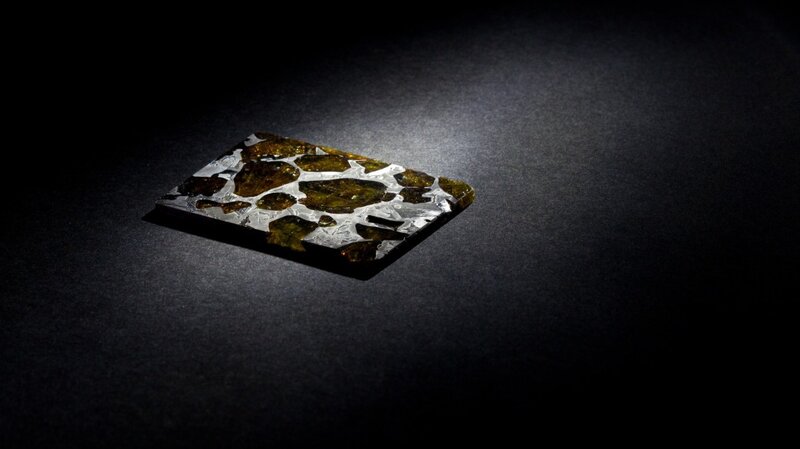 meteorite specimen on dark surface