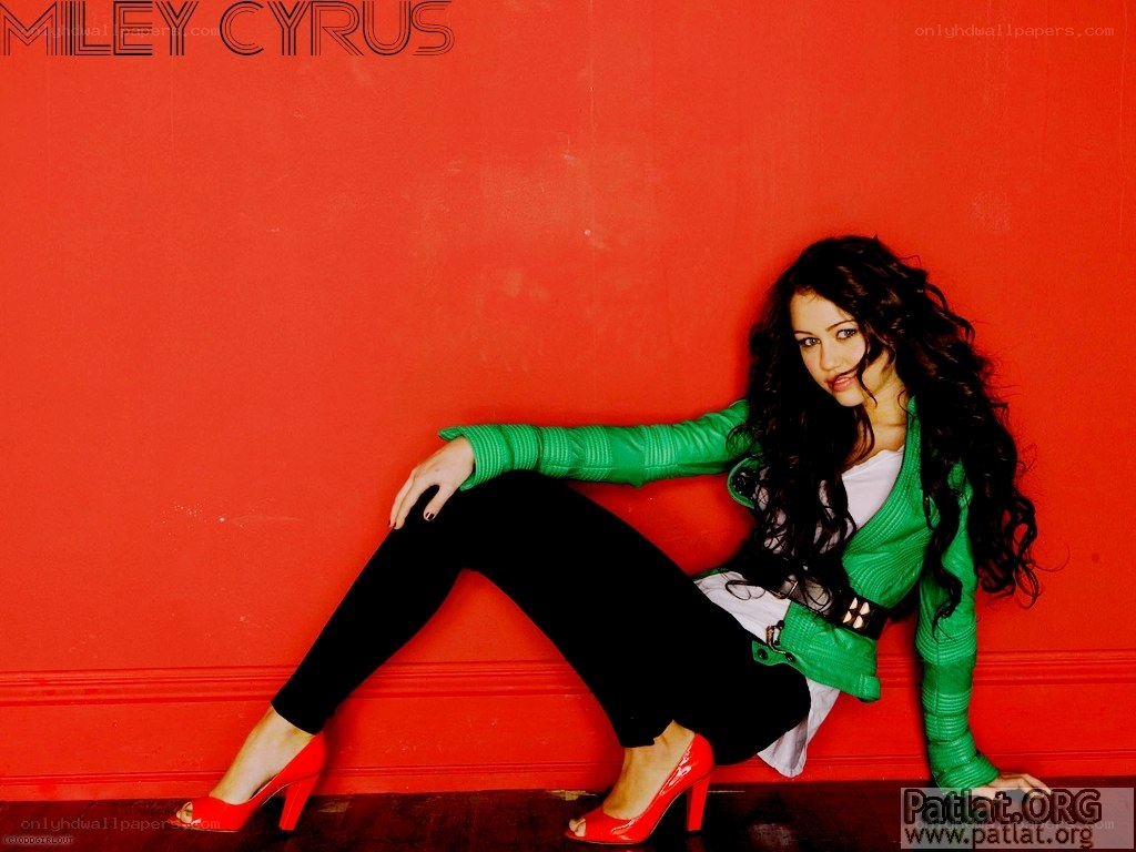 Miley Cyrus posing in green