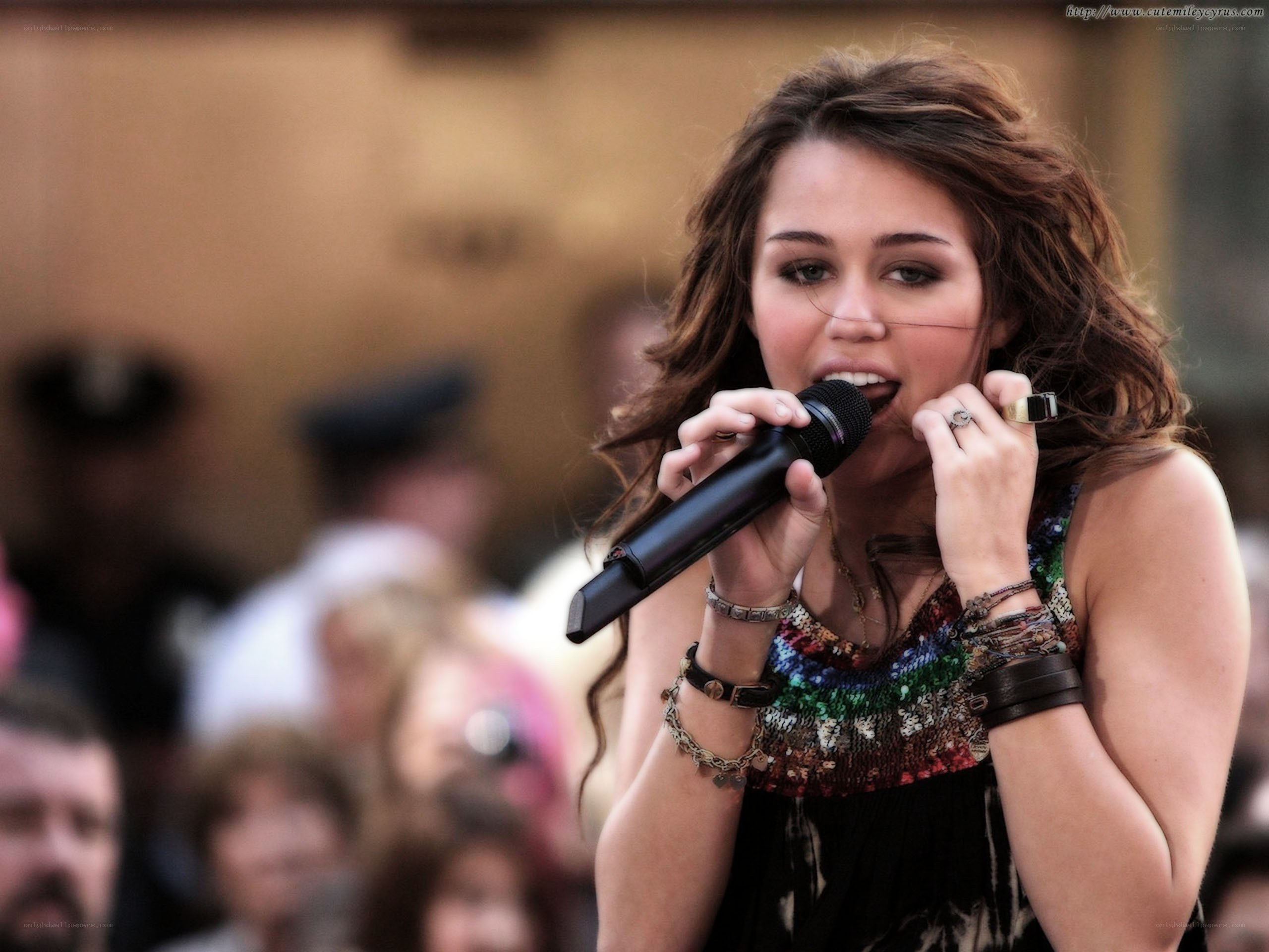 Miley Cyrus singing into a microphone