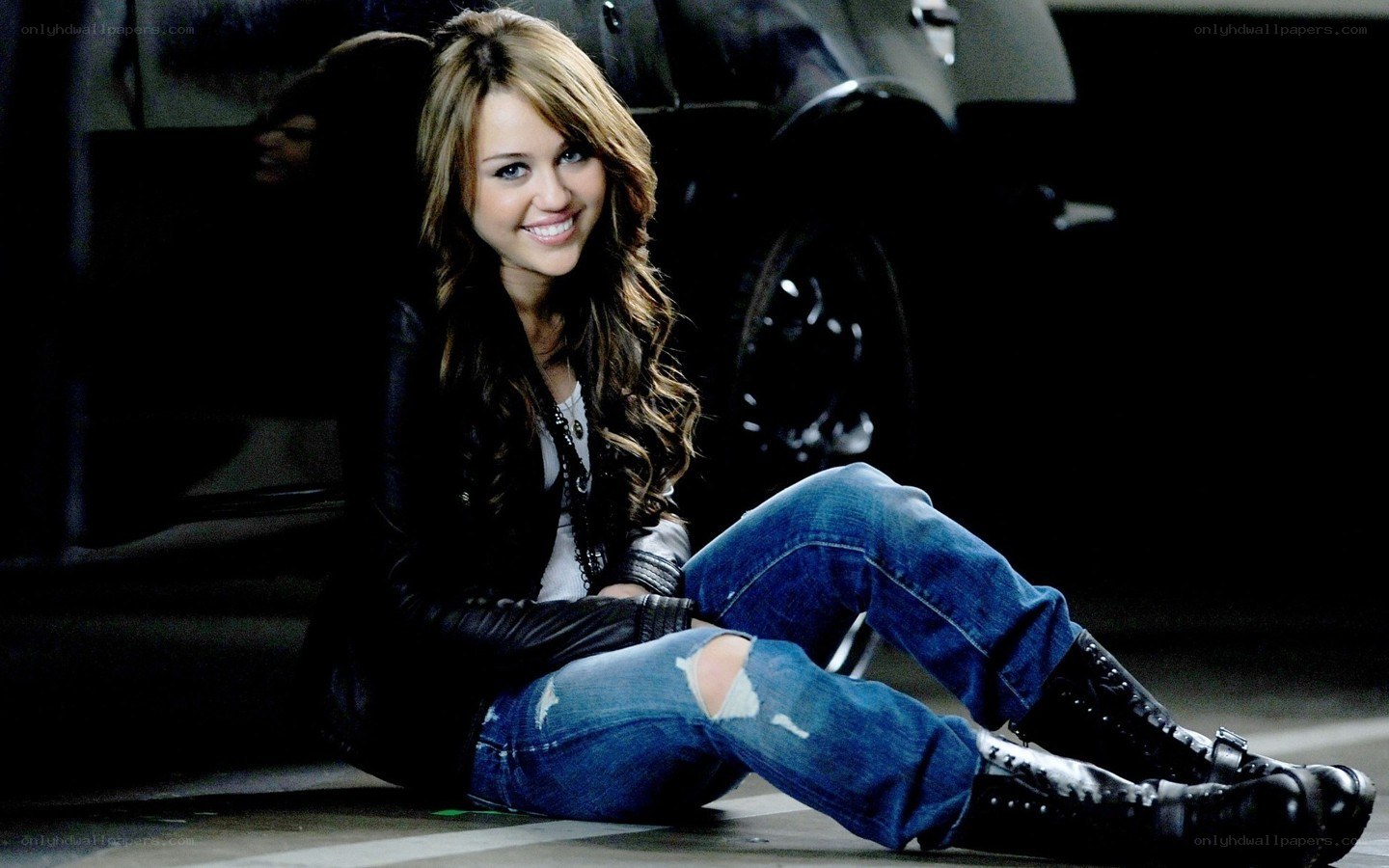 Miley Cyrus sitting on the ground