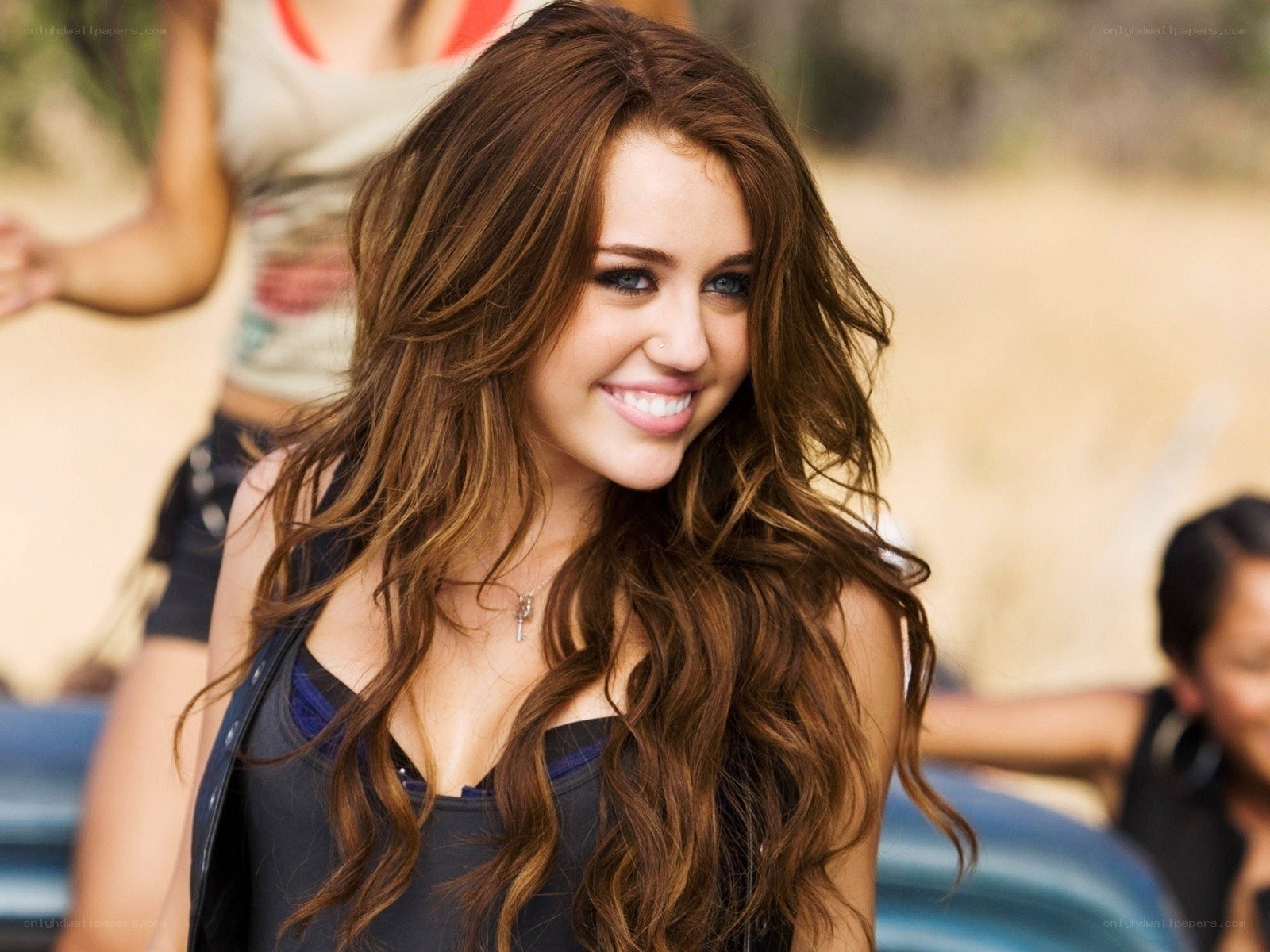 Miley Cyrus smiling in a car