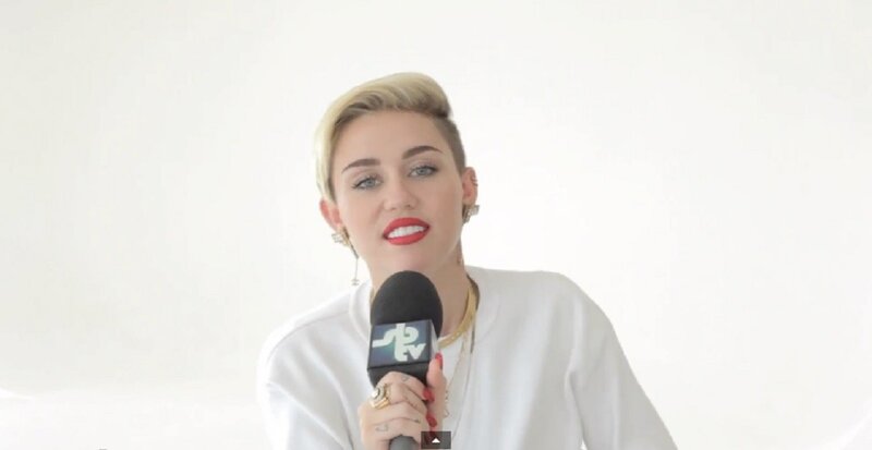 Miley Cyrus speaking into microphone
