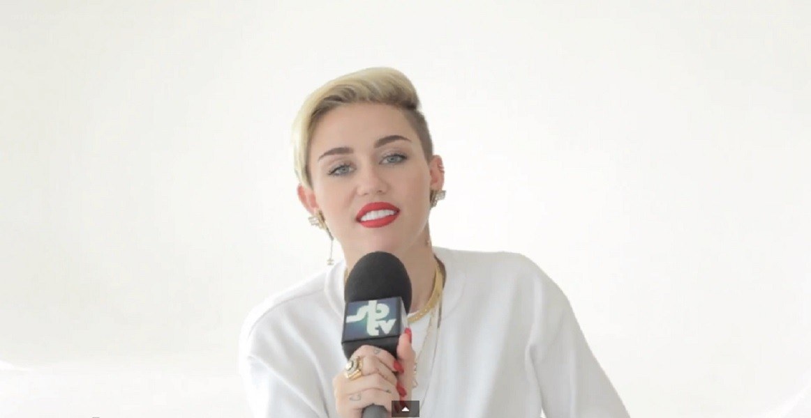 Miley Cyrus speaking into microphone